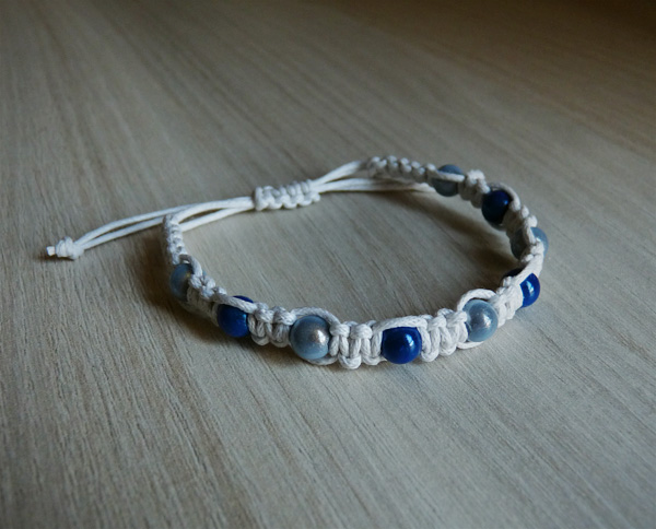 Bracelet blanc avec des perles magiques bleues foncées et bleues claires