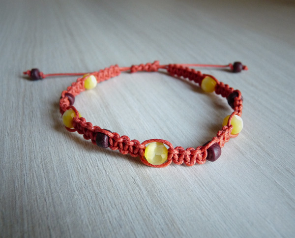 Bracelet orange avec des perles œil de chat facettées jaunes et des perles en bois brunes